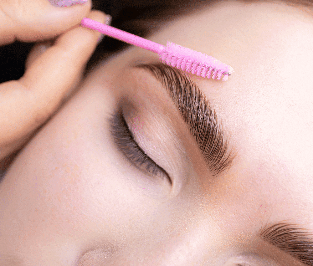 Close-up of person getting eyebrows brushed with spoolie.