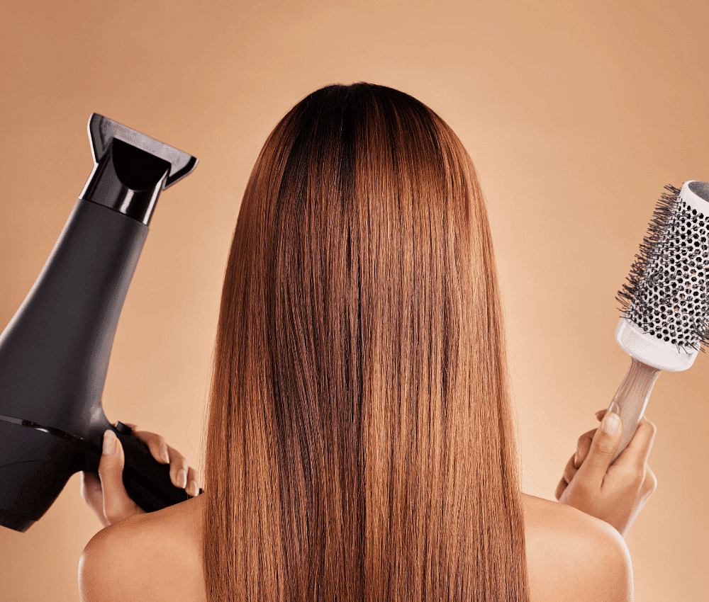 Woman blow-drying long, straight brown hair.